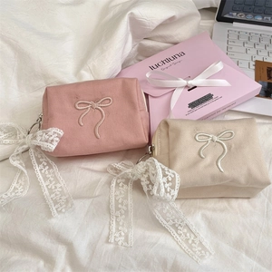 Detail of a sweet bow embroidered cosmetic bag with decorative lace ribbon and twill fabric