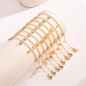 Bracciali dorati in acciaio inox con ciondoli stella cuore e zirconi su supporto bianco