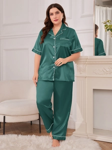 Detail view of dark green satin pajama set with white piping and classic shirt collar