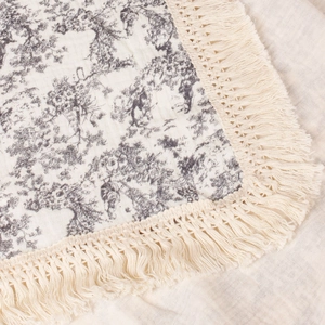 Close-up of vintage sunflower cotton muslin blanket featuring delicate tassel fringe edges