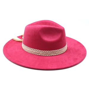 Detail of rose red fedora hat featuring elegant white lace trim and bow on felt fabric
