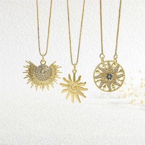 Detailed view of three gold sun necklaces with sparkling blue zircons and box chains