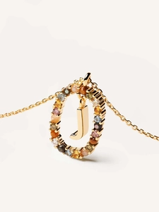 Detailed macro of gold letter J pendant with vibrant multicolored crystal gemstones