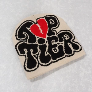 Beige Y2K knit beanie featuring black Top Tier text and a red broken heart pattern
