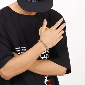 Gros plan d'un bracelet chaîne punk bicolore or et argent porté au poignet d'un homme