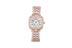 Gros plan de la montre carrée or rose avec aiguilles bleues et bracelet serti de cristaux