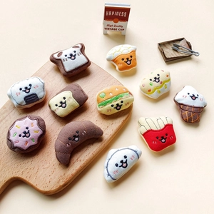 Close-up of assorted plush cartoon food items like toast and burgers on a wooden board