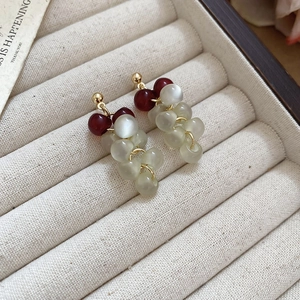 Detailed macro shot of vintage resin grape tassel earrings with colorful beads and gold studs