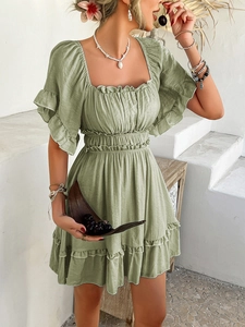 Detail of green square neck short sleeve dress with ruffle hem in summer resort style