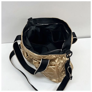 Detailed view of spacious interior with quilted gold fabric and black strap on tote bag