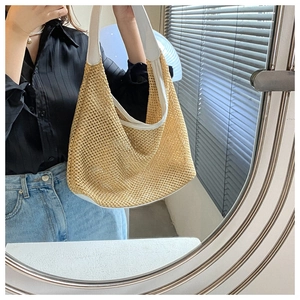 Straw woven tote bag with white leather strap shown on shoulder in a mirror selfie