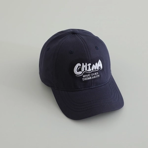 Detailed close-up of navy blue cotton baseball cap with white 3D letter embroidery