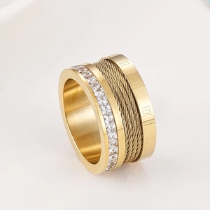 Close-up of golden titanium steel ring with cable texture and Roman numerals