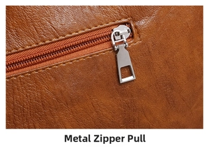 Close-up of premium brown lychee grain leather with a sleek silver metal zipper puller