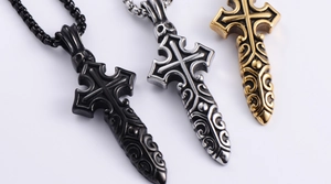 Detail of vintage gothic cross sword pendants in black, silver and gold plated steel