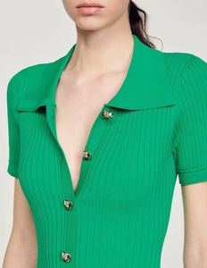 Détail du cardigan en maille côtelée verte avec boutons dorés et col à revers