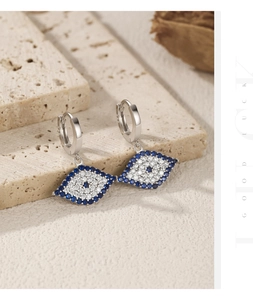 Close-up of S925 silver evil eye earrings with blue and white zircon on stone