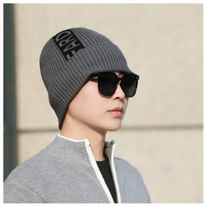 Close-up of men's gray knit beanie featuring a black patch detail and ribbed texture