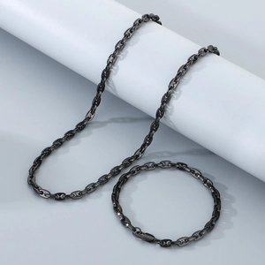 Detail of minimalist black stainless steel pig nose chain necklace and bracelet set