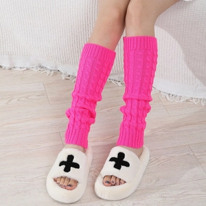 Detail of rose red cable knit leg warmers showing thick knit texture and warm material