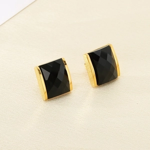 Detail of square black faceted gemstone earrings with textured 18K gold plated frame