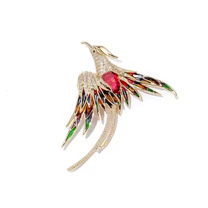 Exquisite gold phoenix brooch with colorful enamel wings and a red oval gemstone center