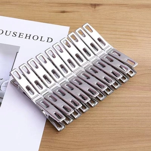 Set of stainless steel windproof clothes pegs on a natural wooden tabletop surface