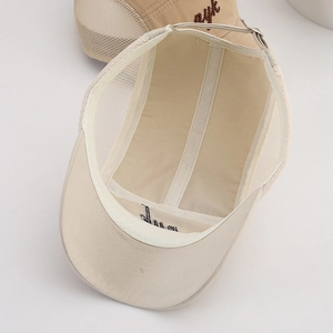 Detailed interior of beige mesh baseball cap showing breathable lining and metal buckle