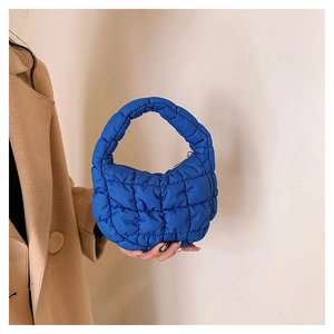 Detailed view of mini blue quilted cloud bag showing puffed texture and zipper