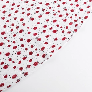 Detalle de tela con rosas rojas y lunares negros con costura de dobladillo bien hecha