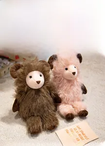Detailed view of fluffy brown and pink goat plushies on a soft rug with a gift box