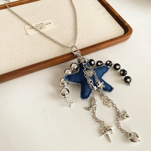 Detailed close-up of Y2K star denim pendant with silver charms on a titanium chain