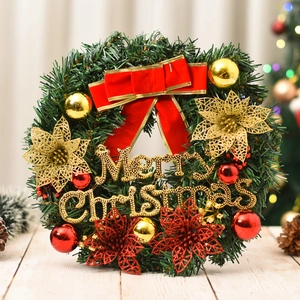 Detail of Christmas wreath with red bow, gold balls, and Merry Christmas text decor