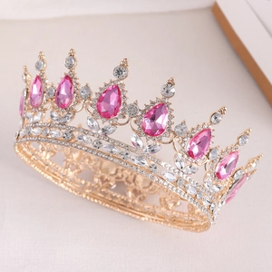 Close-up of golden bridal crown with pink teardrop gems and sparkling rhinestones