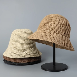 Detailed view of handmade woven straw sun hats in four colors on a professional display