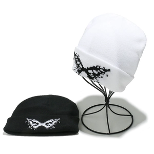 Detail of knitted beanies showing butterfly jacquard patterns in black and white colors