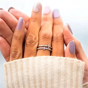 Detail of silver double-layer ring featuring a sparkling cross and pavé stones on hand
