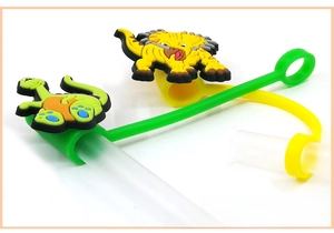 Detailed view of green and yellow silicone dinosaur straw covers for dust protection