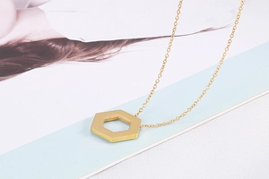 Detailed view of a gold hexagonal geometric pendant necklace with delicate chain link