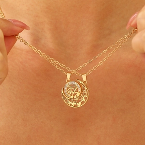 Detail of gold double-layer necklace with sun and moon magnetic heart tree pendant