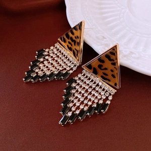 Macro shot of gold leopard print triangle earrings with dangling rhinestone fringe detail
