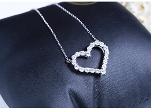 Detailed view of shimmering heart-shaped pendant with full diamond pavé on black leather