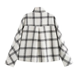 Detail of black and white plaid jacket back featuring inverted pleat and wool texture