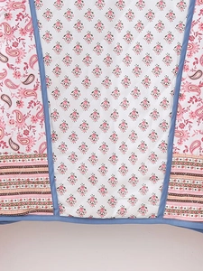 Close-up of quilted floral fabric with paisley patterns and precise stitching detail