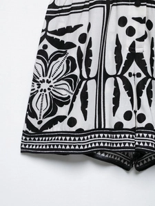 Close-up of bohemian black and white floral print on cotton linen romper shorts