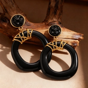 Exaggerated black resin geometric earrings on wood, vintage dark style jewelry