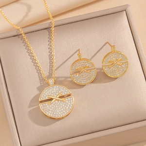 Elegant gold necklace and earrings set featuring circular X-shaped sparkling crystals