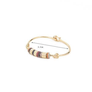 Detail view of 18K gold plated bangle showing colorful zirconia and knot design