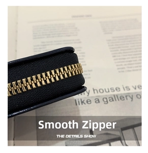 Macro detail of high-quality gold metal zipper on smooth black leather card holder