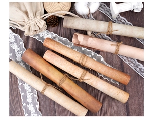 Close-up of vintage A4 craft paper scrolls with jute twine on dark wood background